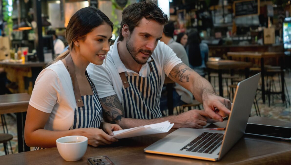 Due dipendenti di ristorante usano il software rilevazione presenze al laptop con Jobby
